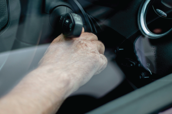 Close up of someone's hand turning the vehicles key in the ignition.
