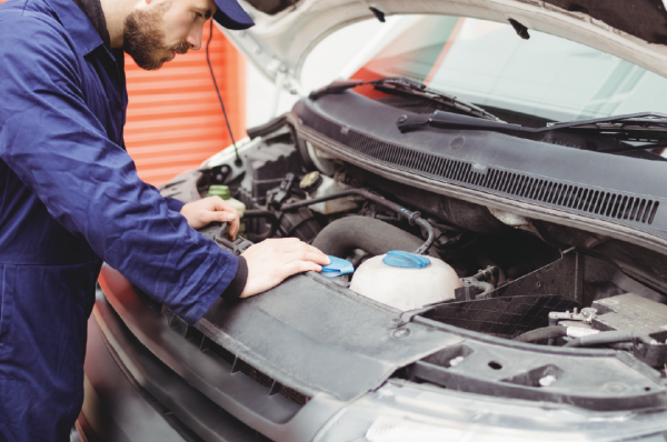 Someone inspecting the engine on a vehicle