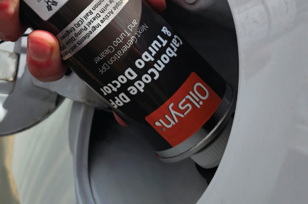 Oilsyn CarbonCode and Turbo Doctor being poured into a fuel tank